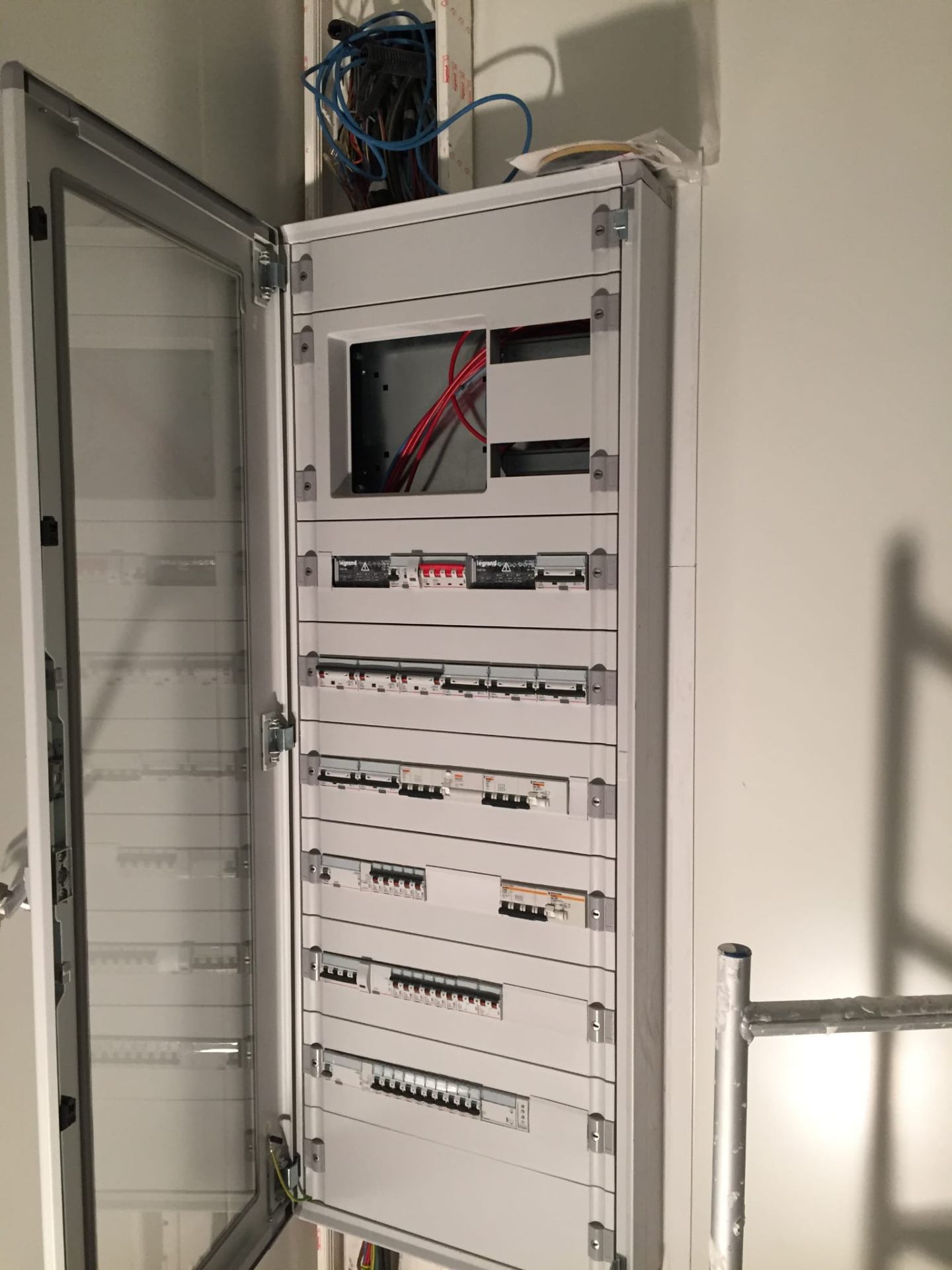 Armoire Legrand ouverte — câblage en cours, disjoncteurs Legrand et Hager