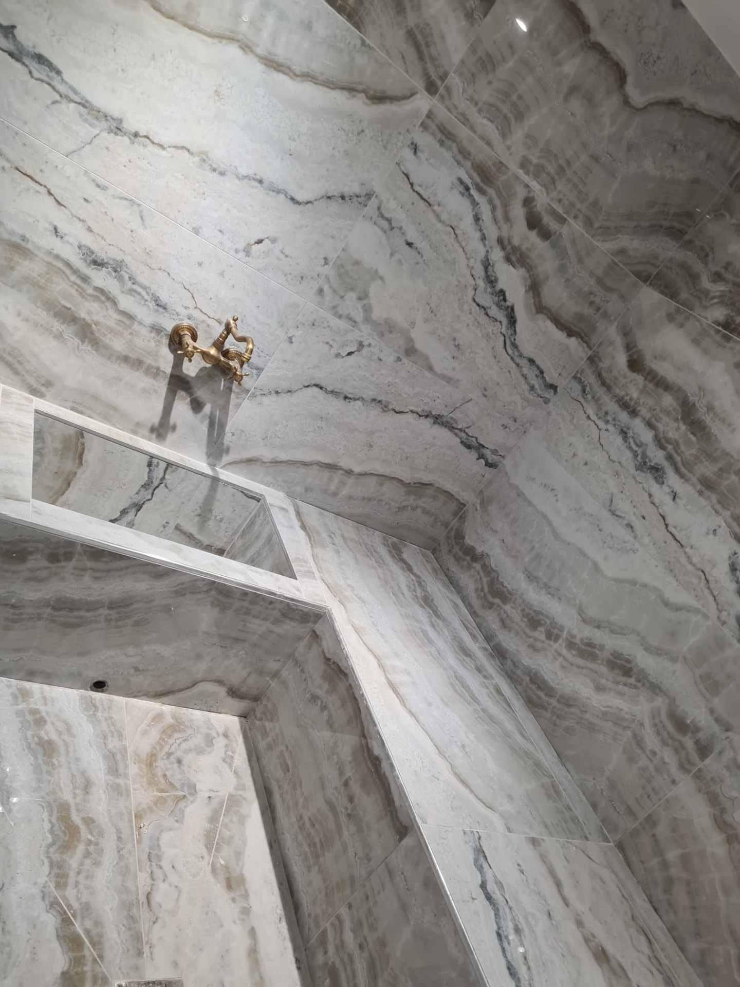 Hammam en onyx — banquette maçonnée et robinetterie rétro laiton